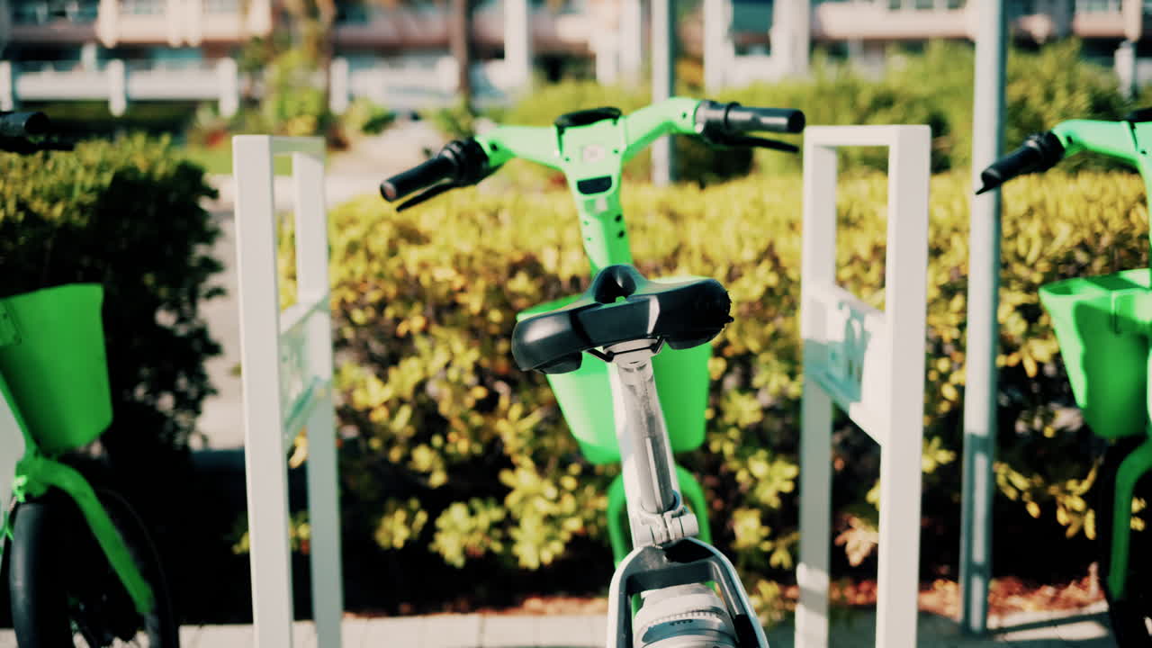 Close up of a green electric bicycle with modern design, parked outdoors under natural light