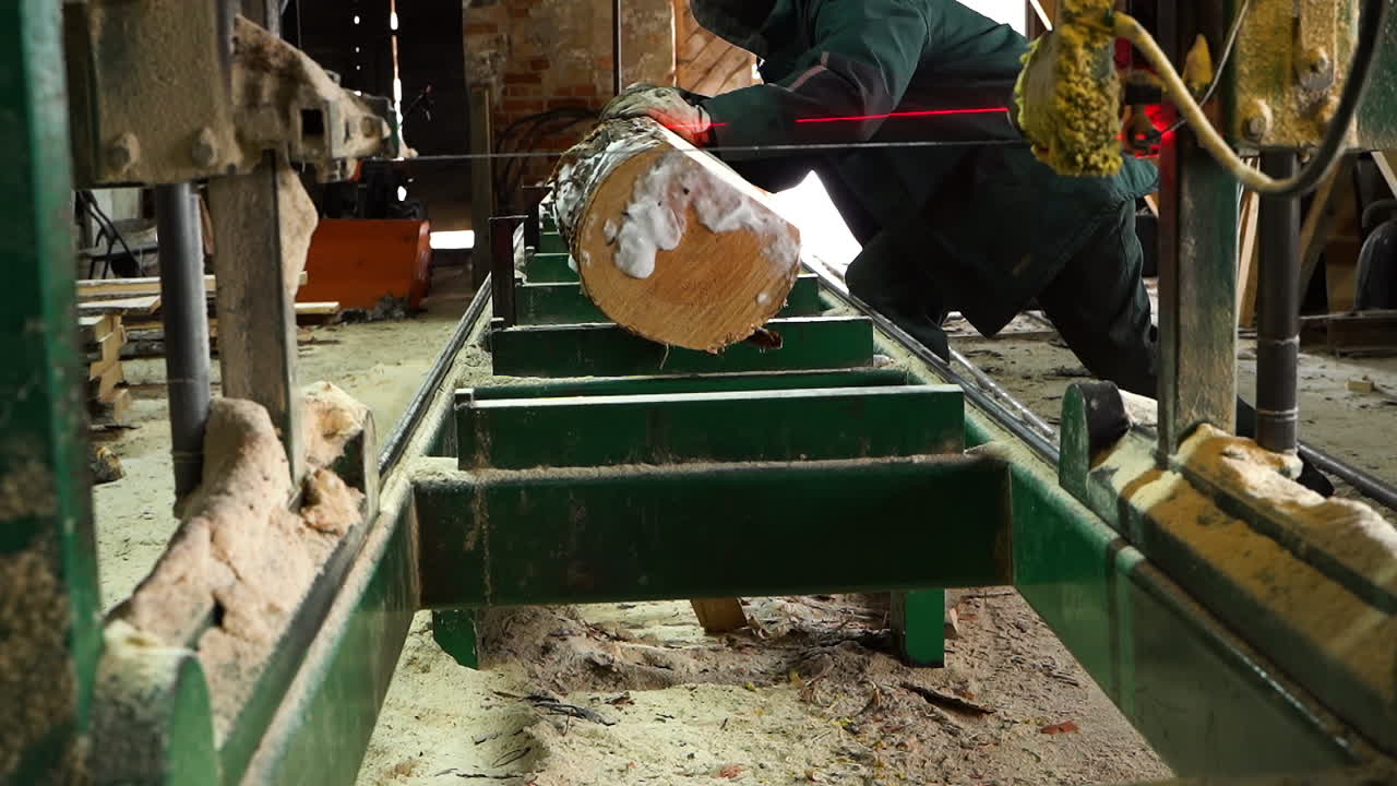 제재소 작업자는 고정된 수평 띠톱, 소규모 가족 사업에 로그를 굴립니다.