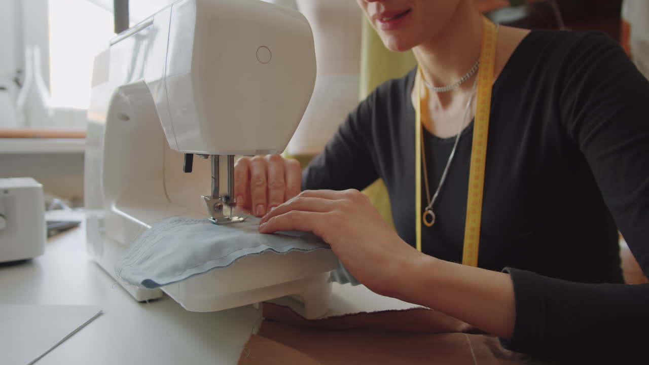 Woman Sewing Clothes on Sewing Machine