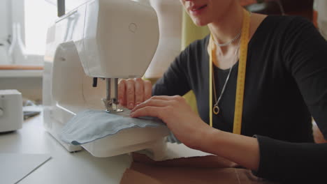 woman sewing clothes on sewing machine