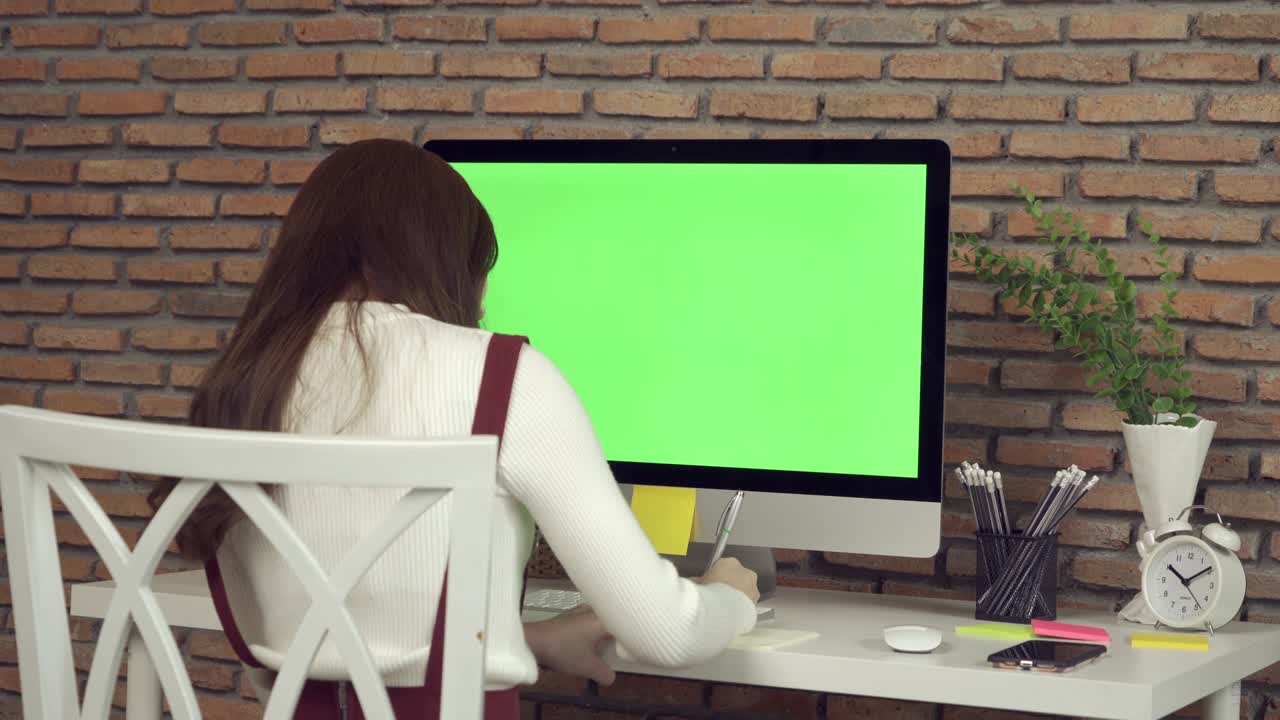 mujer de negocios asiática, joven trabajando desde casa en la mesa con computadora y espacio en pantalla verde en blanco en la webcam videoconferencia de llamada en cuarentena en concepto de virus de corona.
