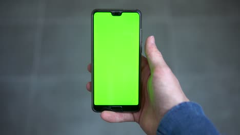 Pov-footage-of-male-holding-mobile-device-with-greenscreen