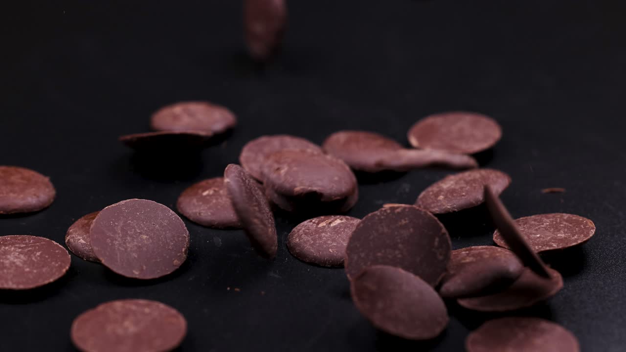 кусочки шоколада падают и рассеиваются на поверхности