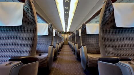empty passenger seats with white headrest covers inside a green car of a shinkansen bullet train in japan