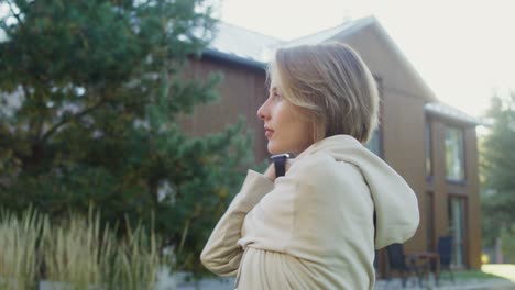 woman in a hoodie outside a house