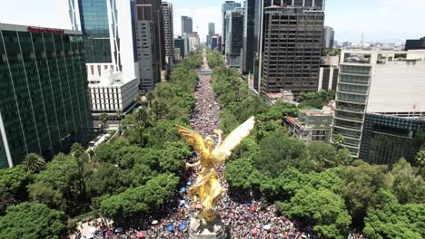 Toma-De-Drones-De-Un-Desfile-Masivo-Del-Orgullo-Gay-En-La-Ciudad-De-México-Con-El-Monumento-A-La-Independencia-En-Primer-Plano