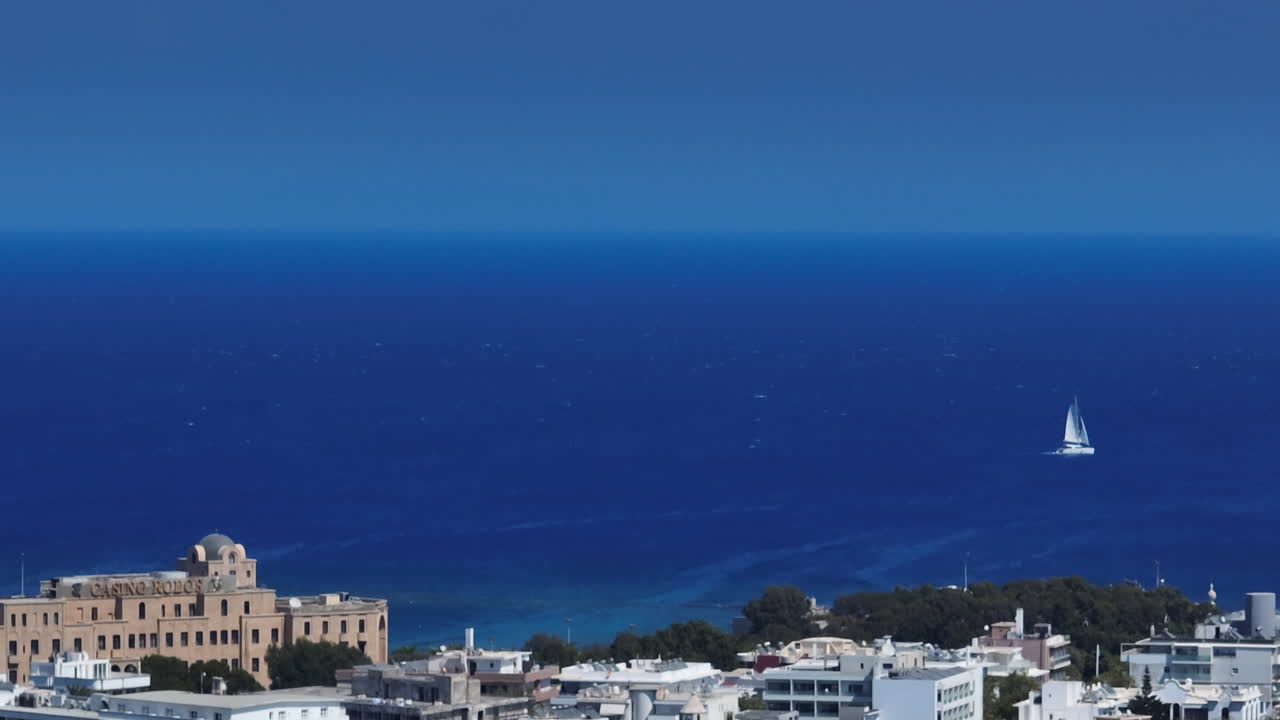 Telephoto drone shot of the cityscape and sea at Rhodes city, in sunny Greece