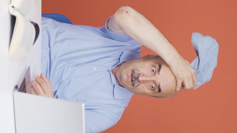 Vertical-video-of-Old-man-looking-at-laptop-in-amazement.