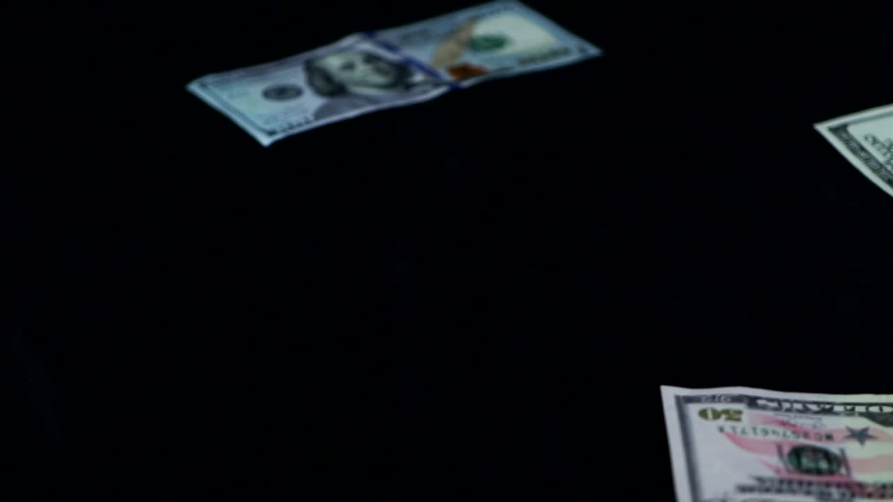 Dollar Bills Slowly Thrown And Scattered On Black Surface