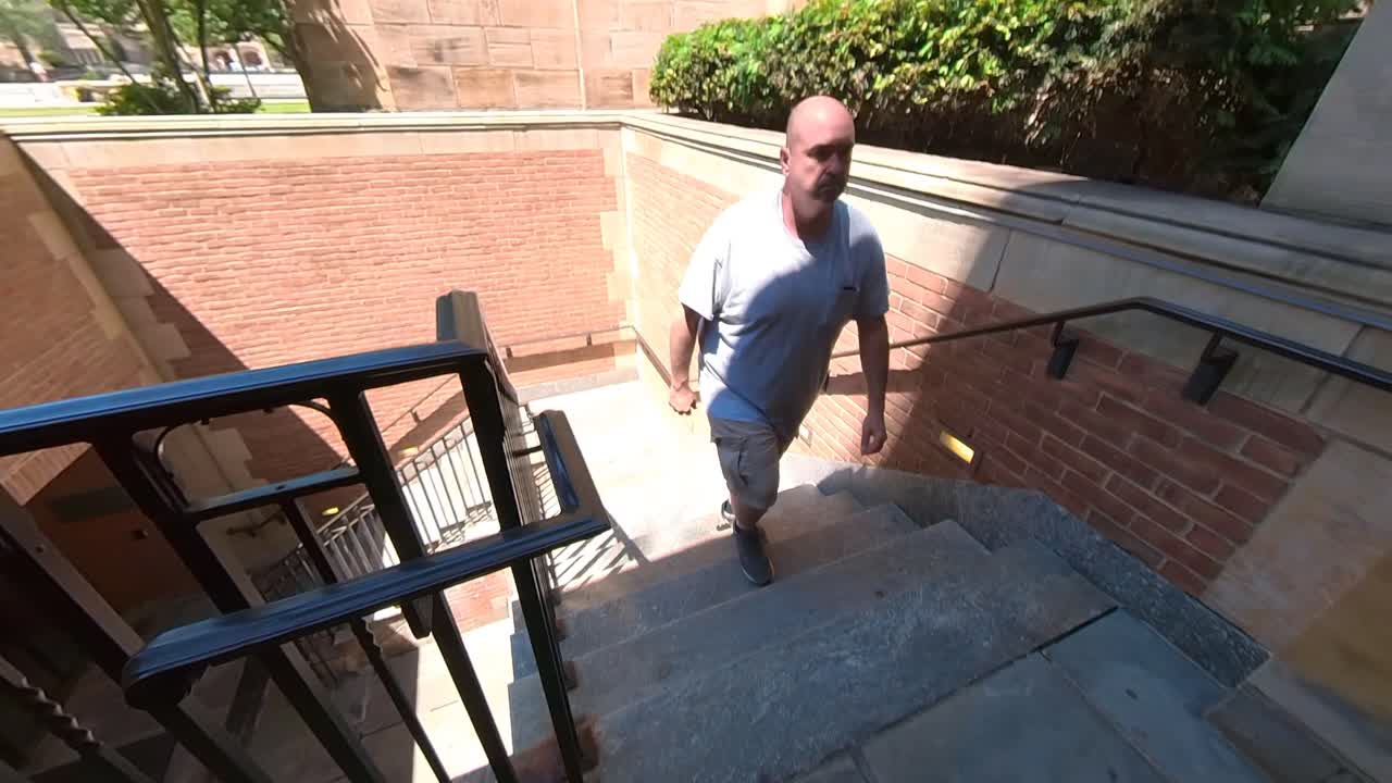hombre subiendo escaleras en el campus 4k