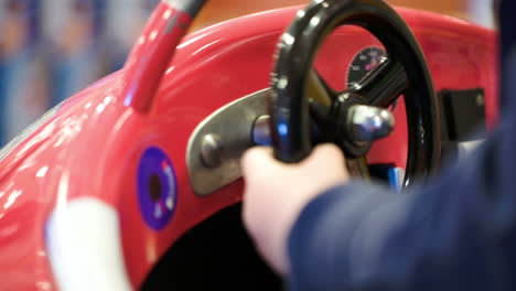 niño girando el volante de un coche de juguete