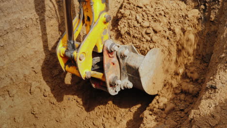 excavator bucket driven by powerful hydraulics removes soil from the trench pipeline laying