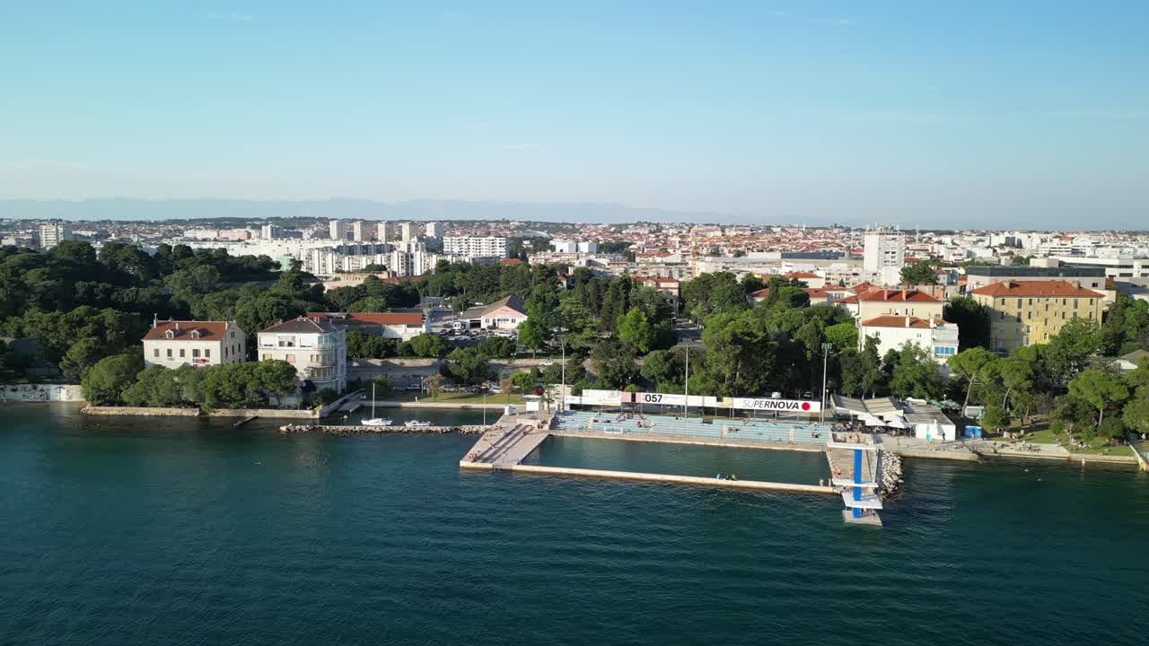 panorama costero aéreo más amplio zadar sobre la piscina de mar con plataforma de buceo y ciudad en el fondo