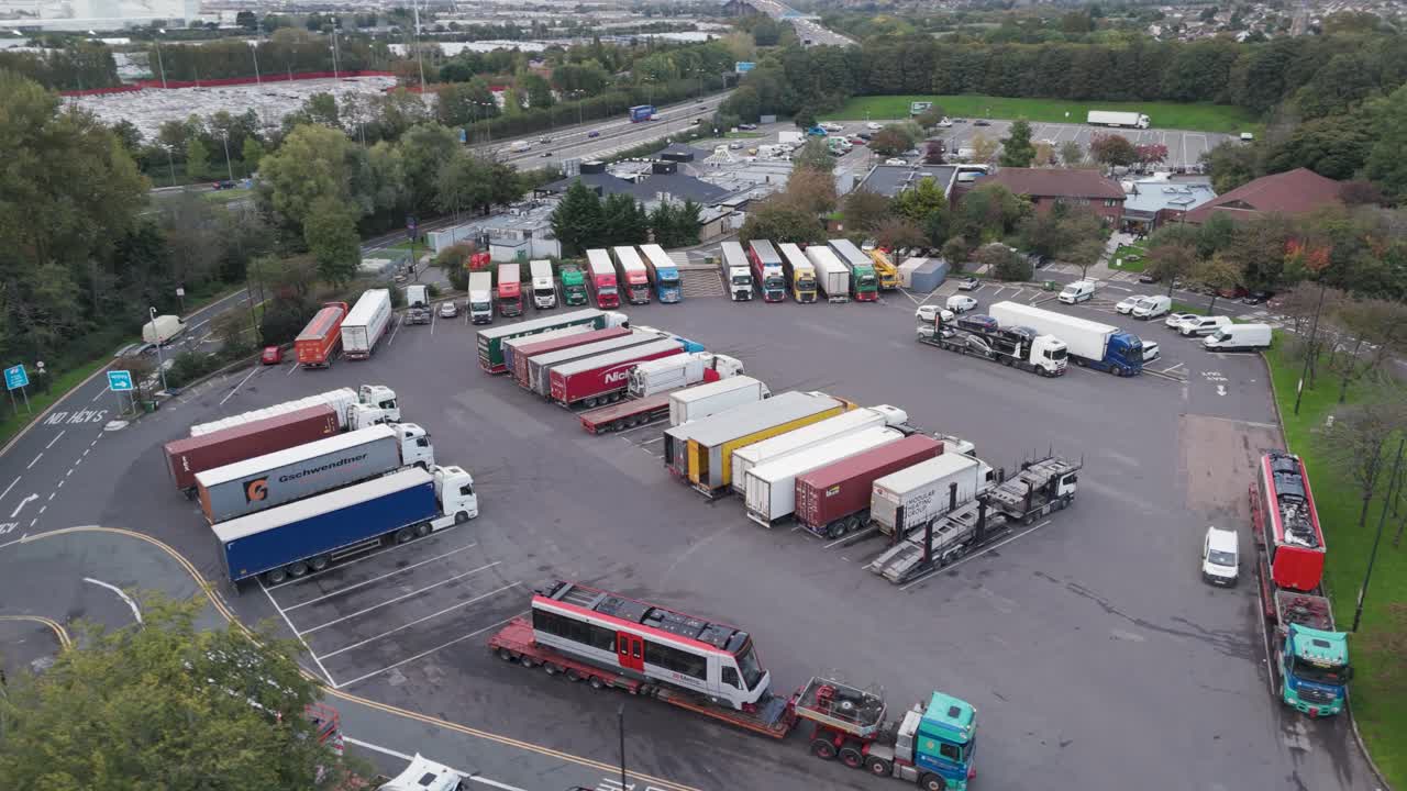 Aerial orbital view of Gordano motorway services showing truck parking area, service facilities and vehicle arrangement, Bristol, UK, October 2024