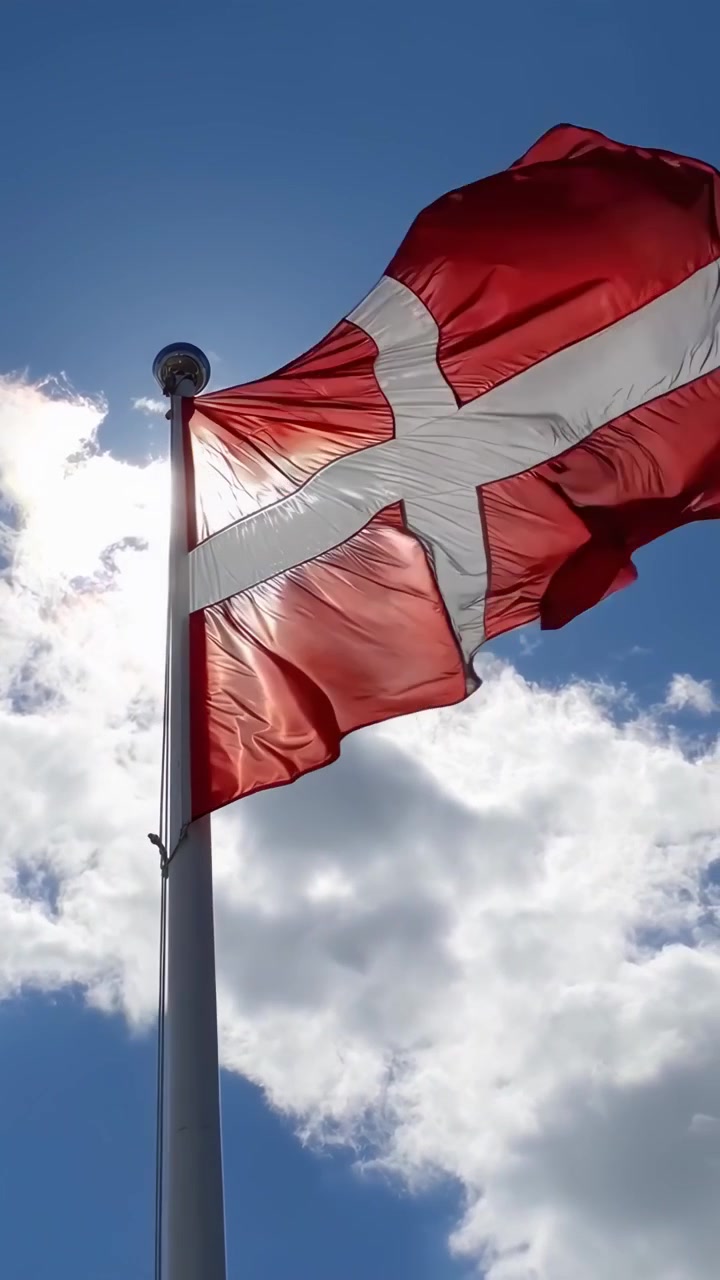 Klart dansk flag vajer i vinden på en solrig dag