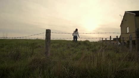 woman running through barbed wire field