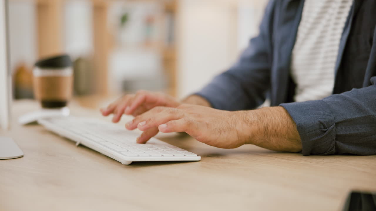 Person typing on a keyboard at a desk