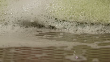 Macro-of-a-sponge-with-soap-cleaning-the-metal-kitchen-surface