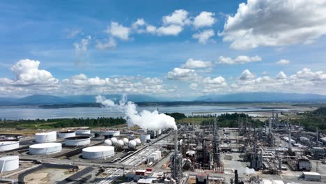 Aerial-shot-of-fumes-pouring-out-of-a-smokestack-at-a-petroleum-refinery