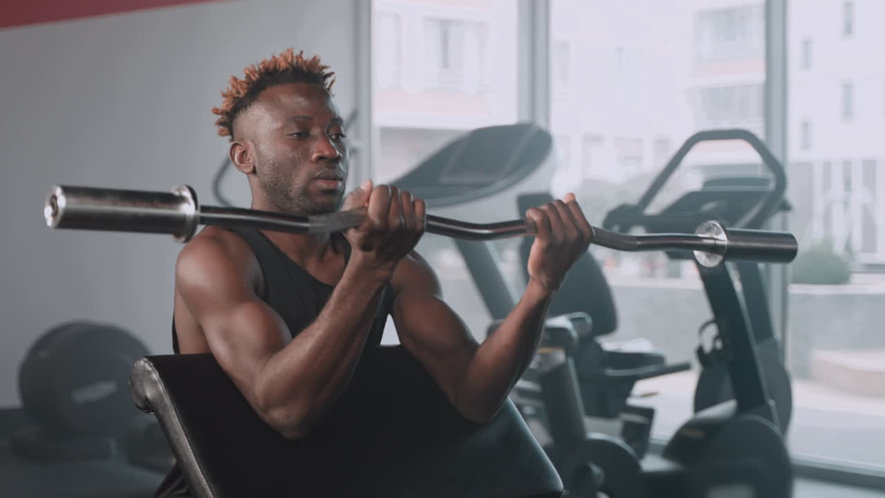 Man Working Out with Barbell in Gym