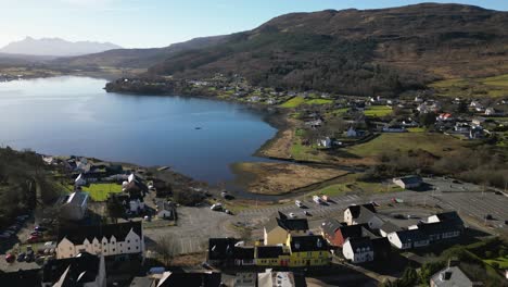 flying high over buildings towards harbour of portree isle of skye scotland