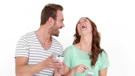 una pareja sonriente enviando mensajes de texto y de pie de espaldas.