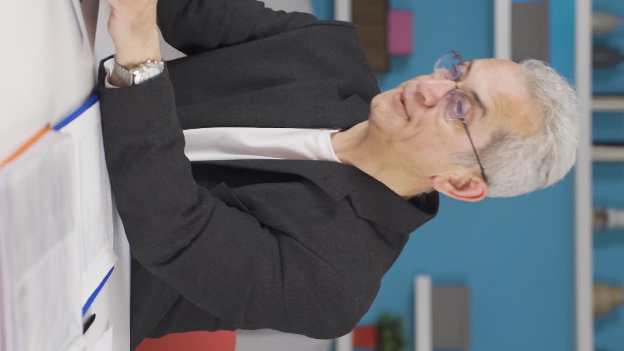 video vertical de un hombre que trabaja en una oficina en casa se está asfixiando por el calor.