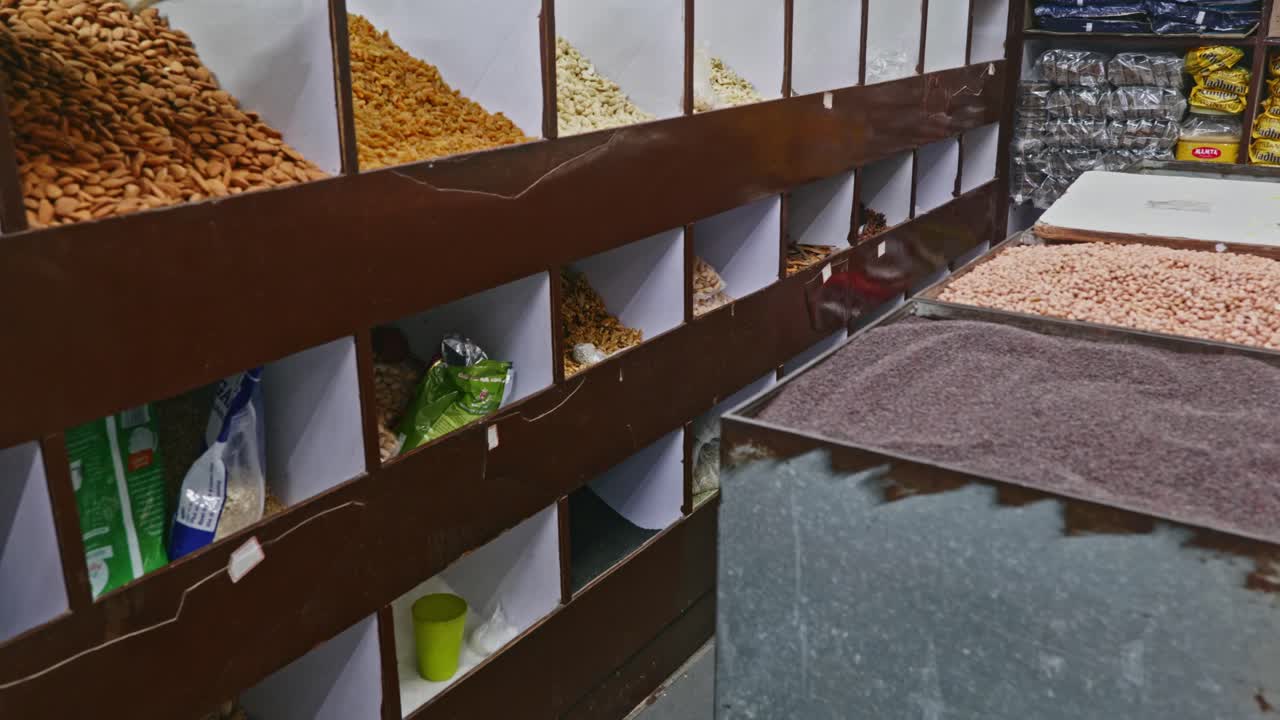 Almonds, Raisins, Cashew nuts and other dry fruits stored in wood rack with mustard and peanuts to sell at kirana store. stable shot, 4k.