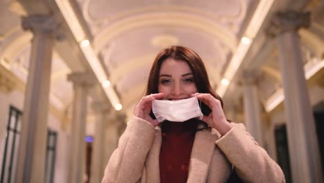 beautiful girl in fashionable clothes holds and wears disposable mask