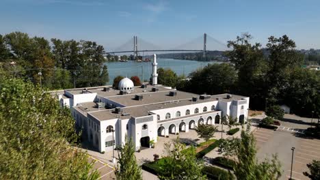 Flying-Over-The-Baitur-Rahman-Mosque-Towards-The-Fraser-River-With-Alex-Fraser-Bridge-In-Delta,-BC,-Canada