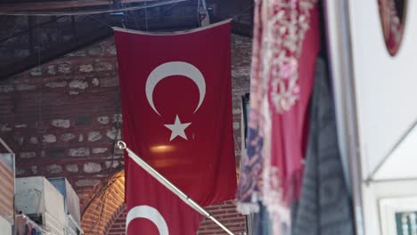 bandera roja de turquía con diseño de estrella y media luna colgando del techo en el mercado