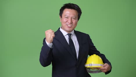 mature japanese businessman against green background