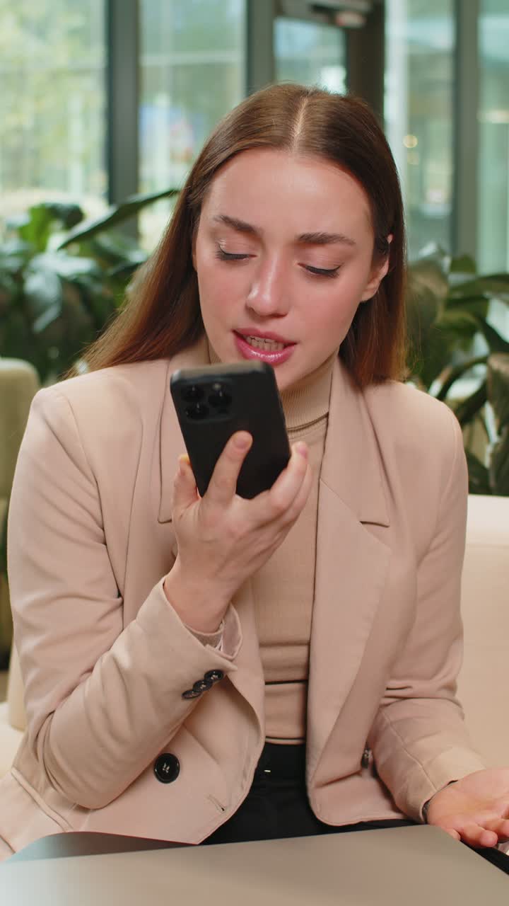 스마트폰으로 대화하는 동안 논쟁하는 사업가 여성은 현대 사무실 로비에서 나쁜 소식을 표현합니다.