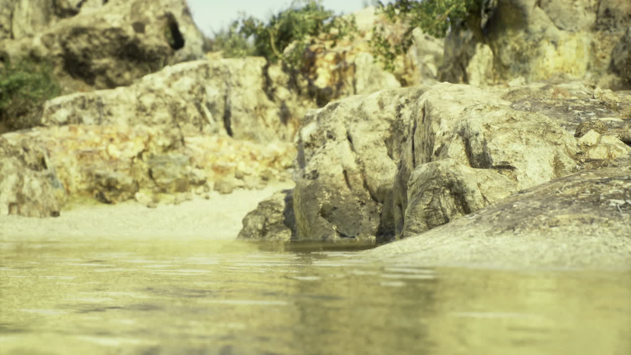 Explore tranquil waters beside rocky shores in a sunlit coastal retreat