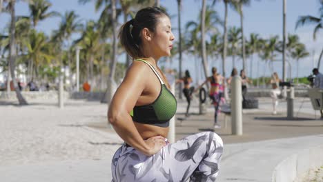 Woman-standing-and-working-out-in-park