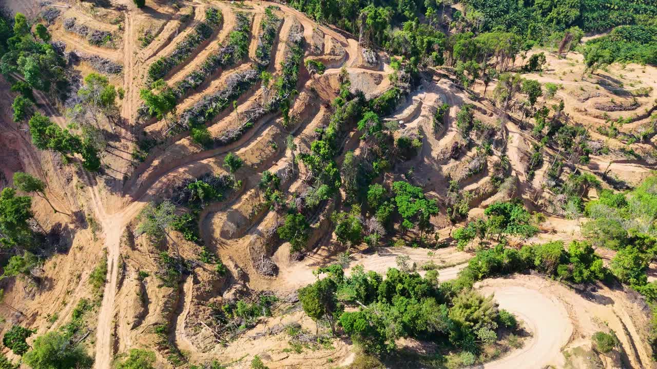 Drone footage captures a terraced quarry in Phang Nga, Thailand, showcasing lush greenery and winding paths under bright sunlight