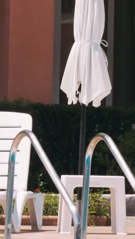 people sitting by the poolside of a resort swimming pool during summer holiday