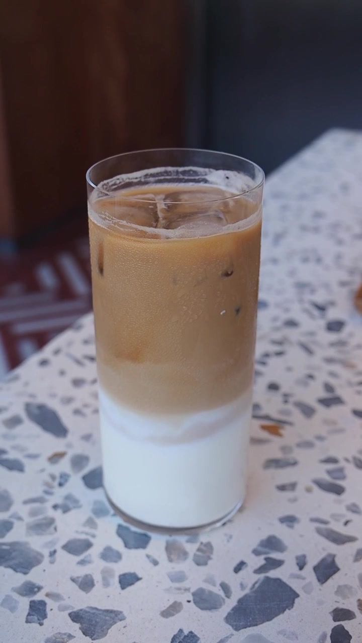 Bicchiere di latte macchiato freddo su un tavolo in terrazzo.