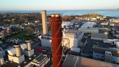 backwards reveal from power station chimney revealing industrial area, harbour covering area from leale’s yard to vale castle and sea beyond, st sampson guernsey in late afternoon sun