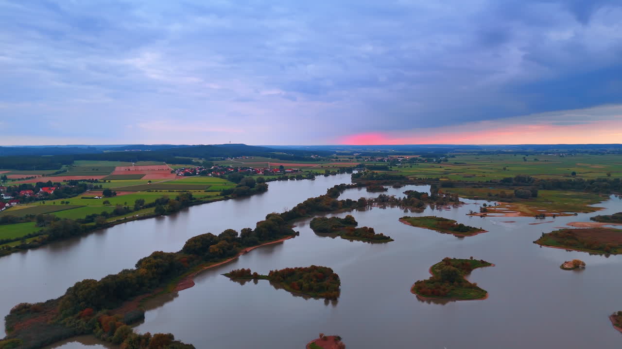 River islands at sunset. German river landscape with small islands under dramatic sunset clouds