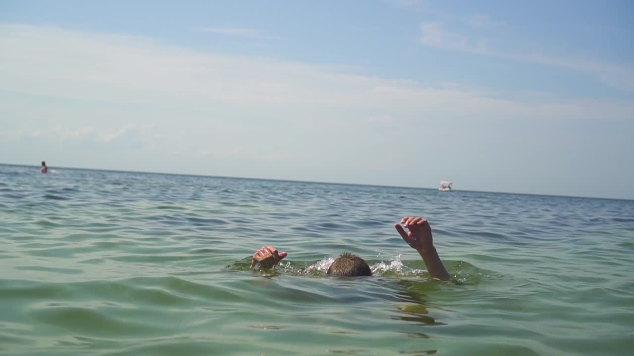 las manos de un hombre ahogándose en el mar 01