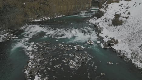 scenic flowing river by aldeyjarfoss waterfall in snowy iceland landscape - aerial