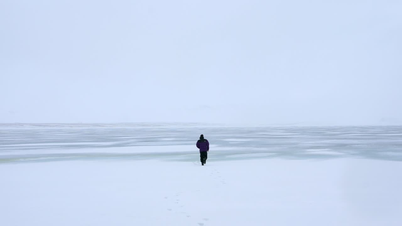 Persona che cammina su un lago ghiacciato in inverno