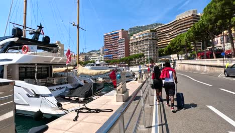 cyclist rides along marina with yachts docked