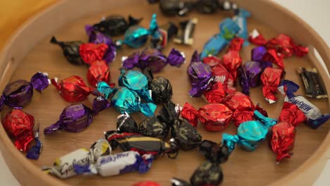 wooden tray filled with a variety of colorful, individually wrapped chocolates