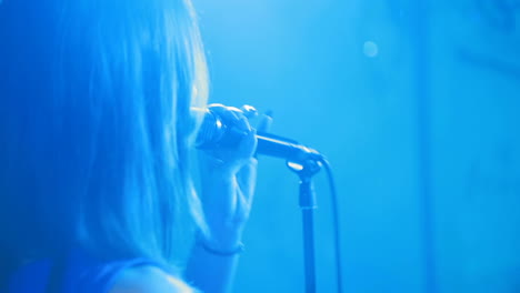 woman artiste singer with a microphone in her hands sings on stage