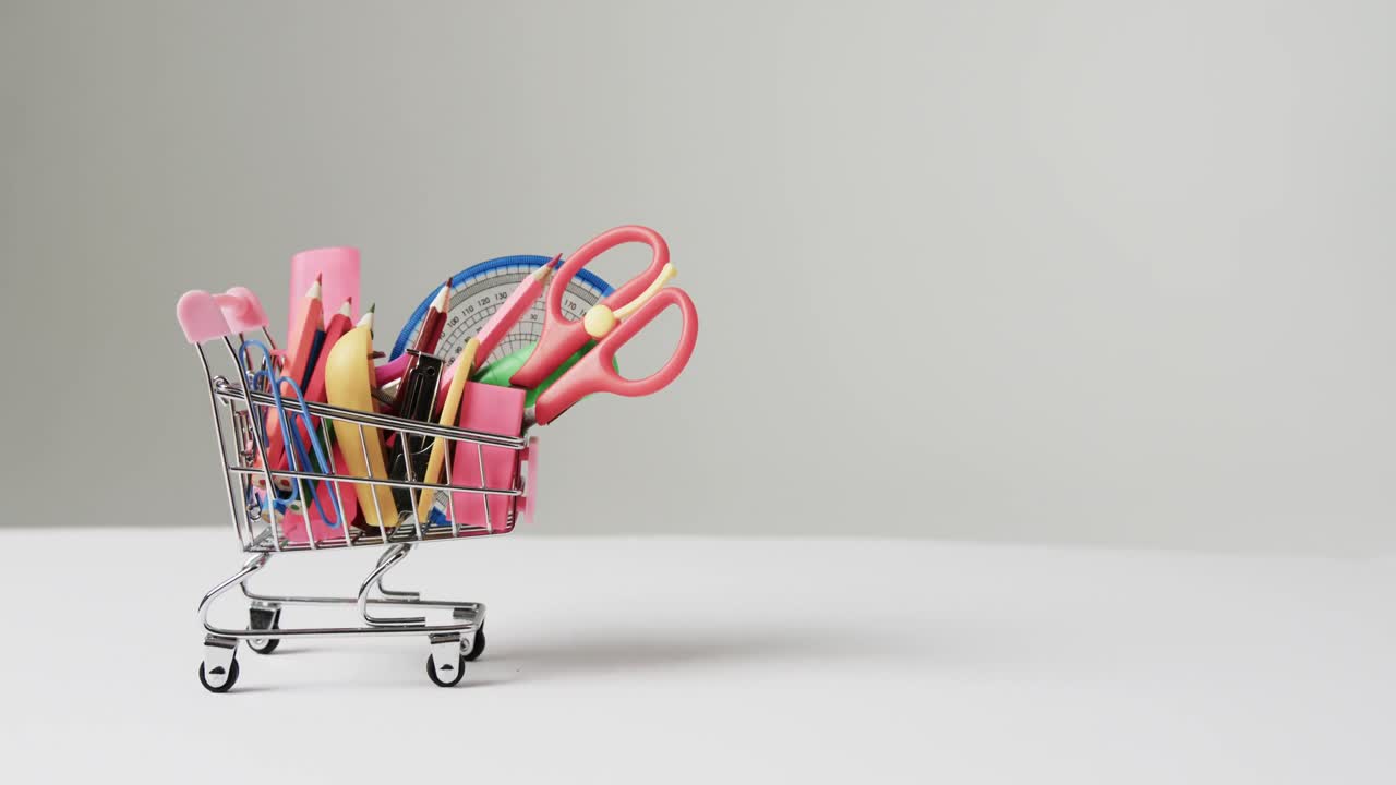 cerca del carrito de compras con artículos escolares y espacio de copia en fondo gris