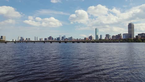 aerial fly over charles river toward harvard bridge, boston city skyline