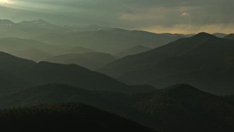 aerial view of idaho springs, colorado, capturing the forested mountain ranges at dusk with a serene sunset in the background