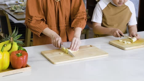 mom and boy cutting bananas.